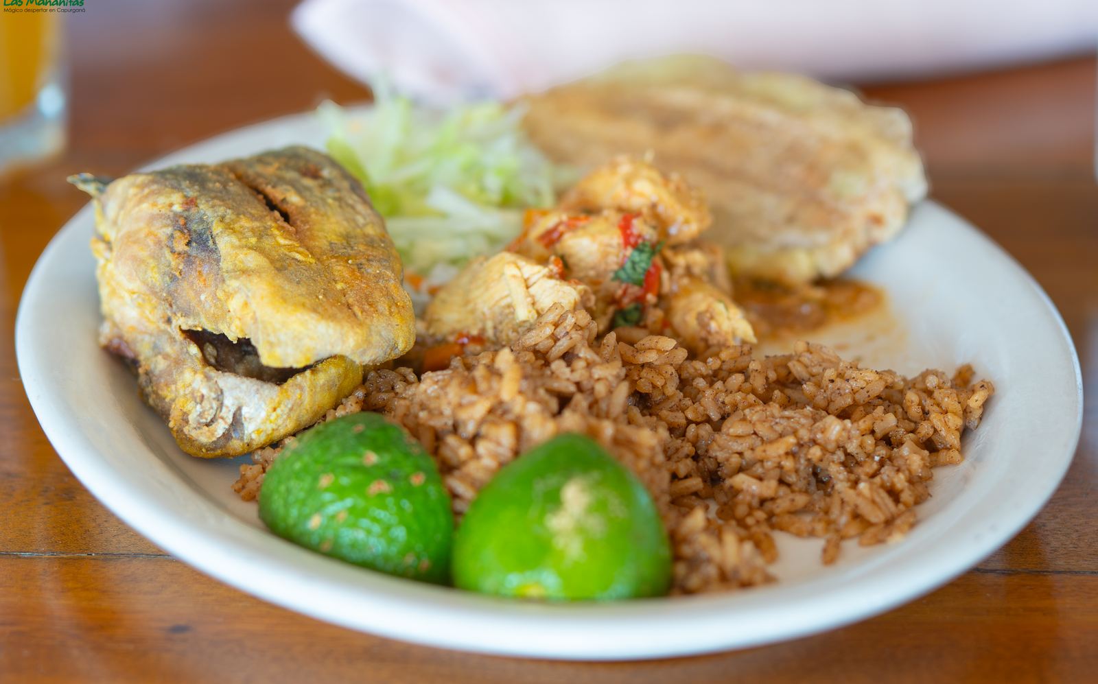 Fried fish with coconut rice, patacón and lime