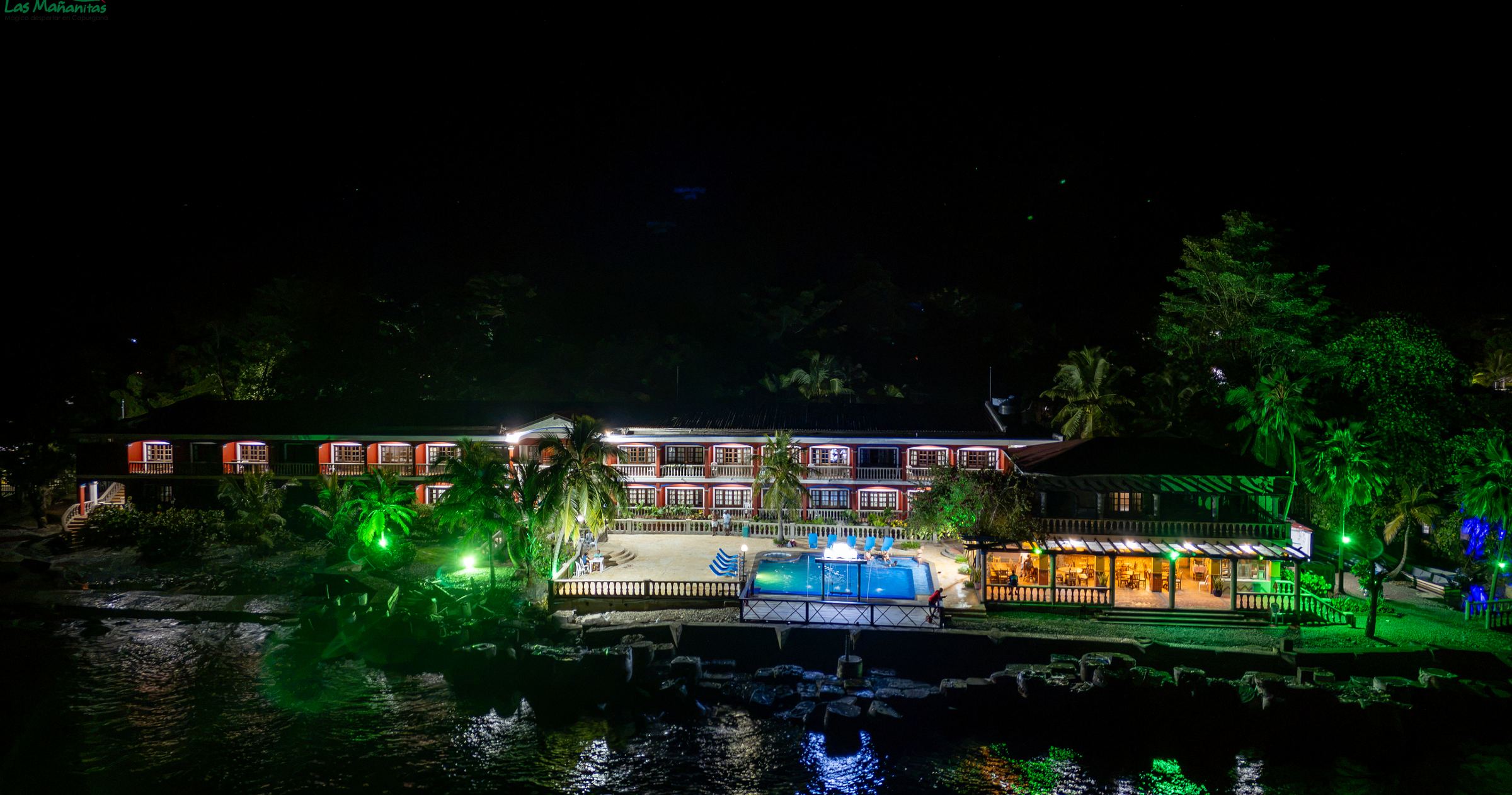 The hotel lit at night from the water